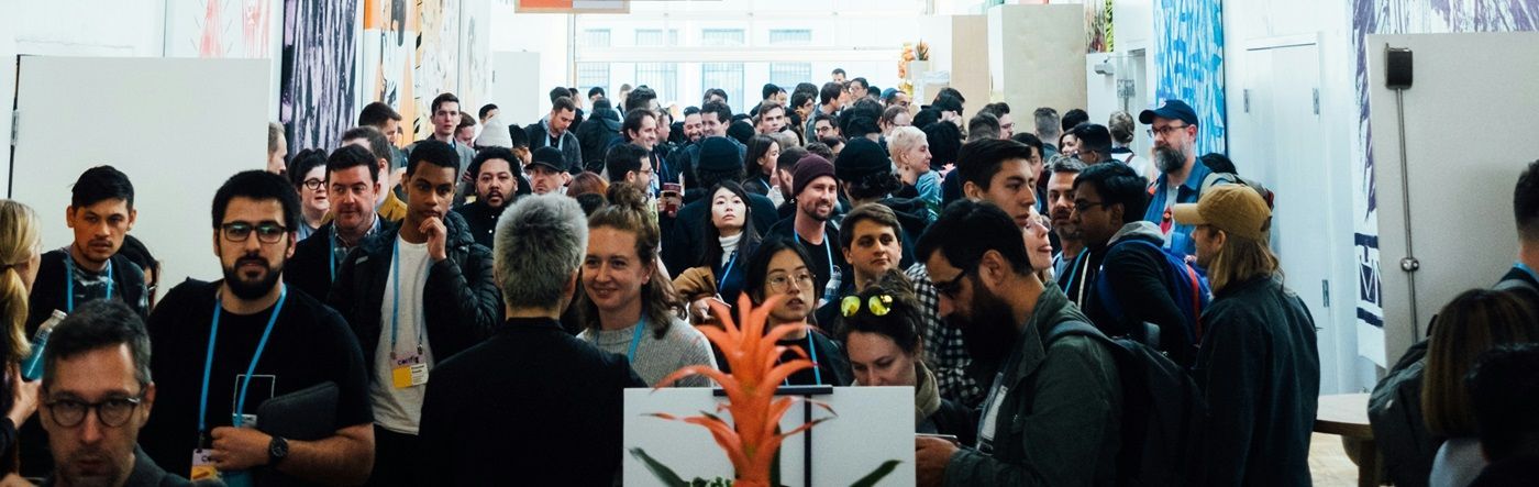 A large group of people are standing in a hallway.