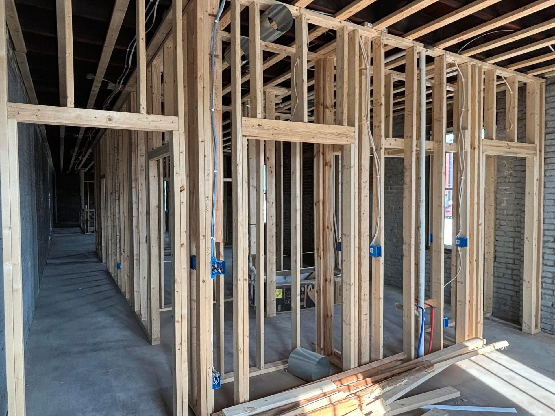 Interior of a house under construction with unfinished wooden framing and concrete floors
