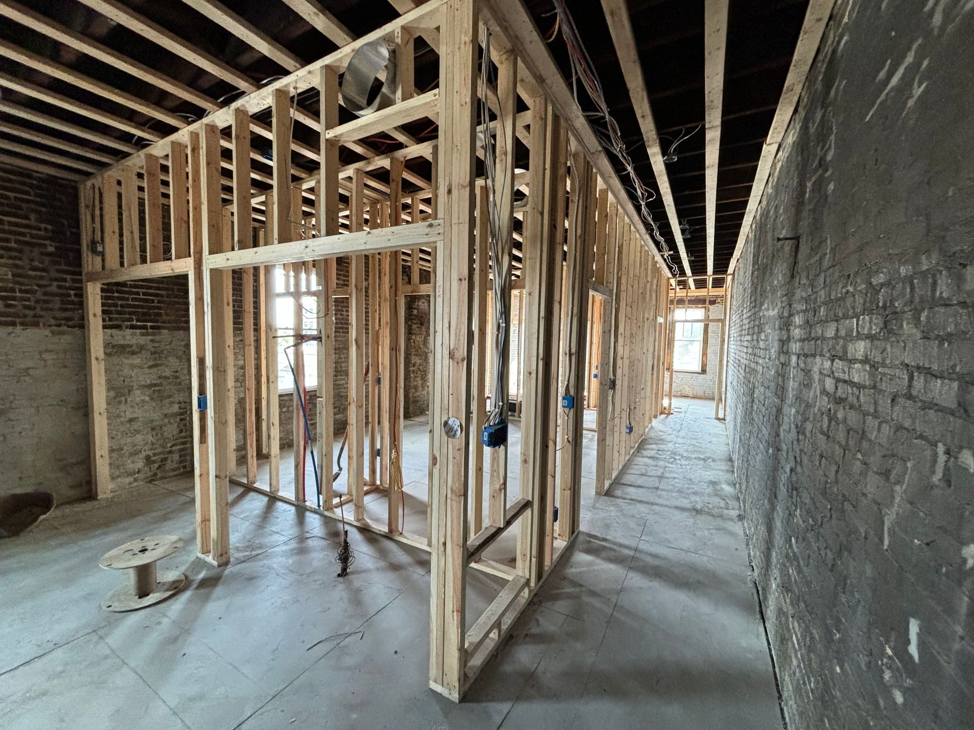 Interior of a building under construction with wooden framing and exposed concrete walls and floor