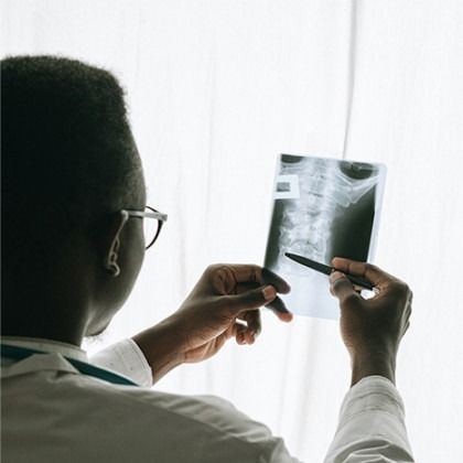 Doctor examining a chest X-ray with a pen in a bright clinical setting