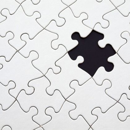 White jigsaw puzzle with one missing black piece in the center