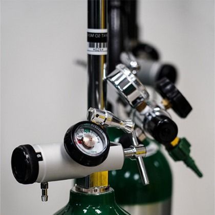 Diving tank valves and gauges with white regulators attached to green cylinders