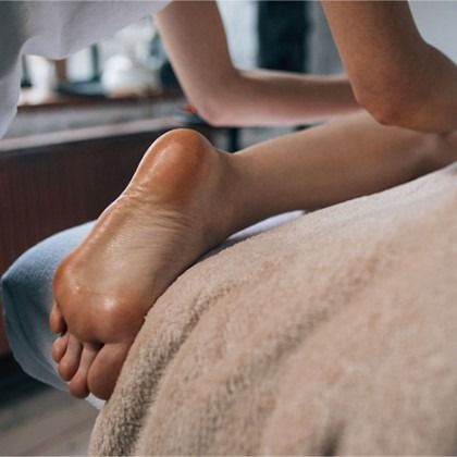 Close-up of a person’s feet resting on a massage table during a spa treatment