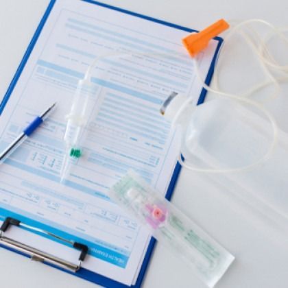 Clipboard with medical forms, syringes, and a face mask on a white background