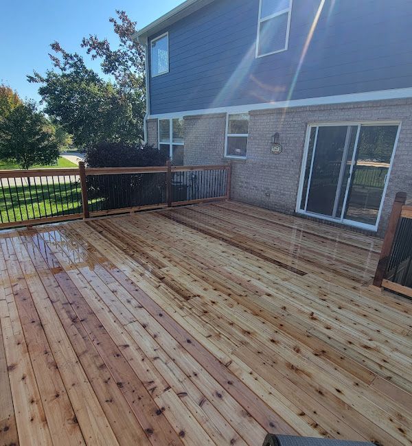 A wooden deck in front of a house with sliding glass doors
