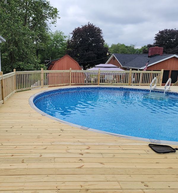 A large swimming pool is surrounded by a wooden deck.