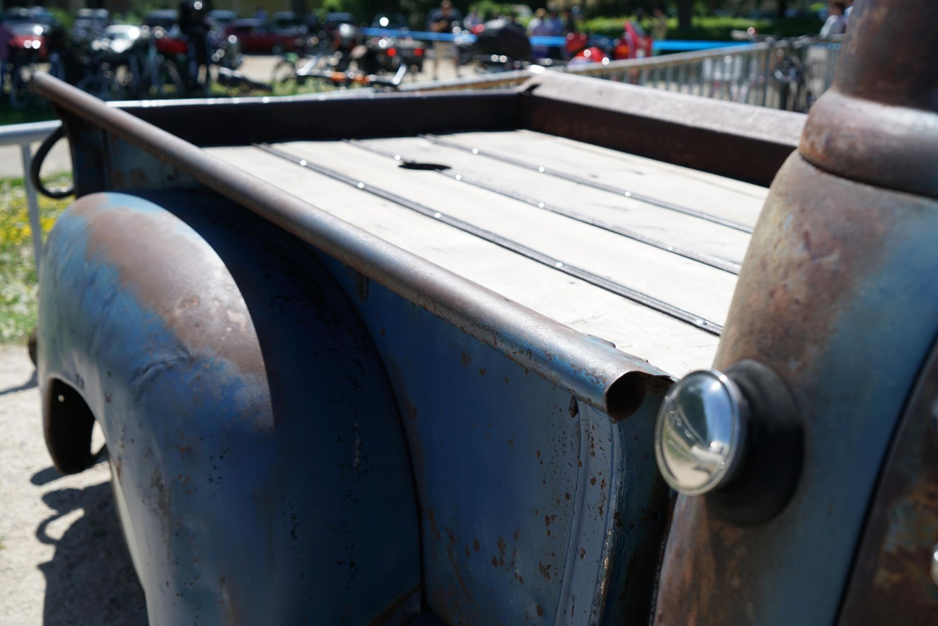 Old, rusty truck, under the sun, with a truck bed cap.