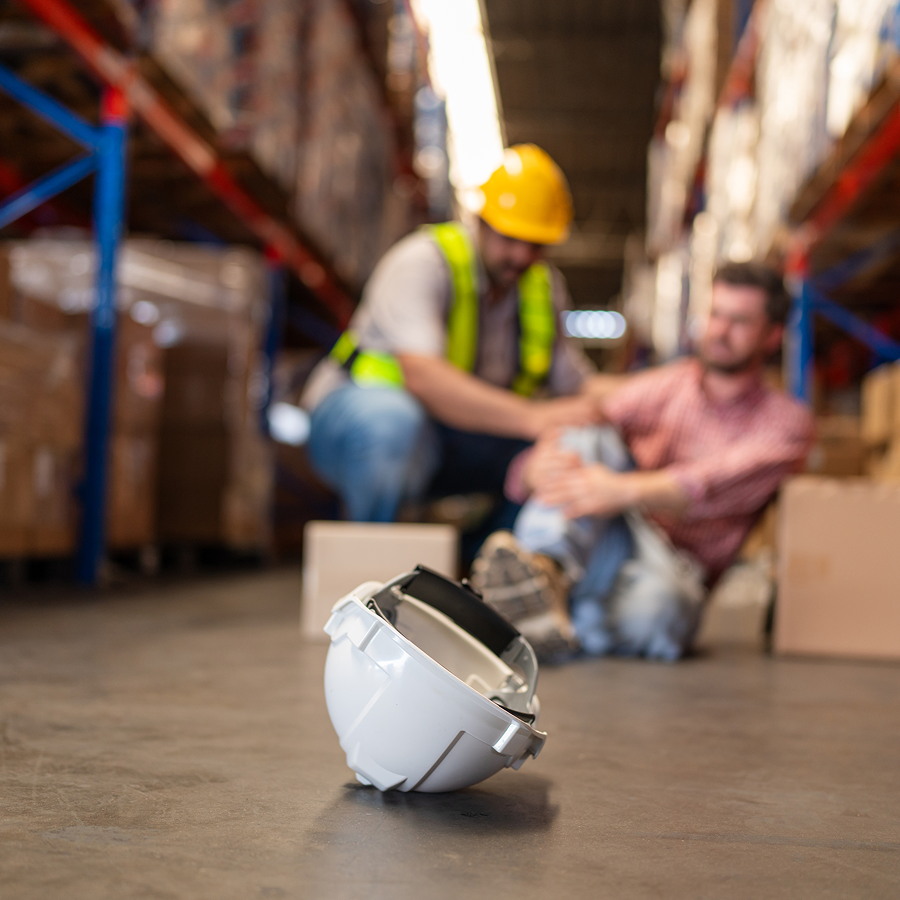 A hard hat is laying on the floor in a warehouse.