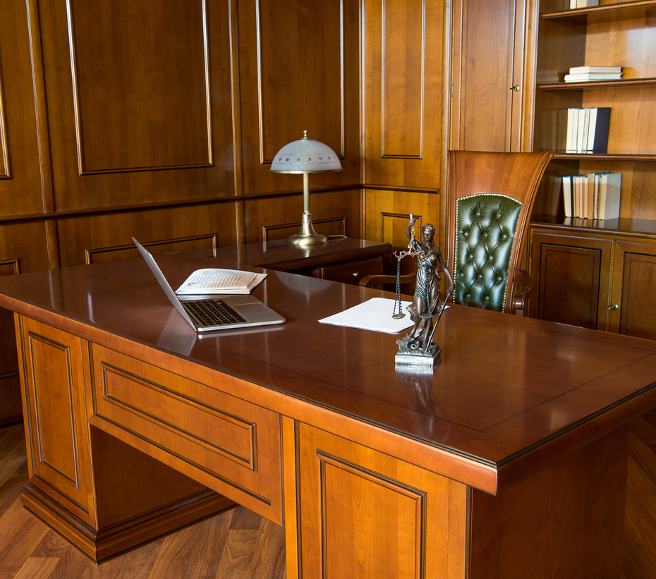 A wooden desk with a laptop on it