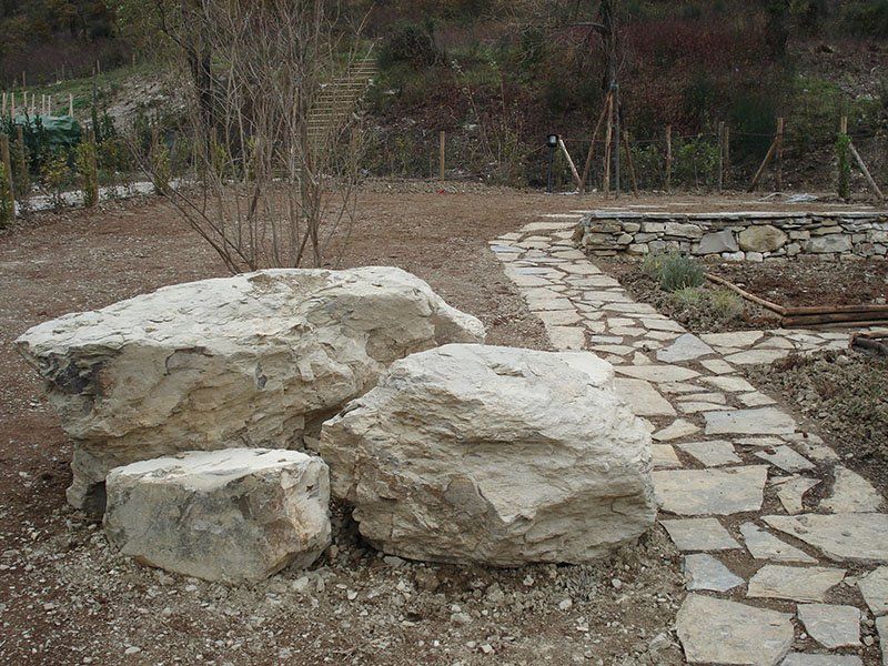 Un gruppo di grandi rocce si trova accanto a una passerella di pietra.