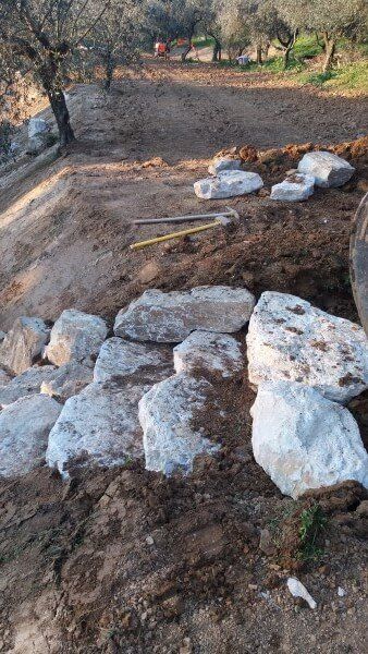 Un mucchio di rocce in cima a un campo sterrato.