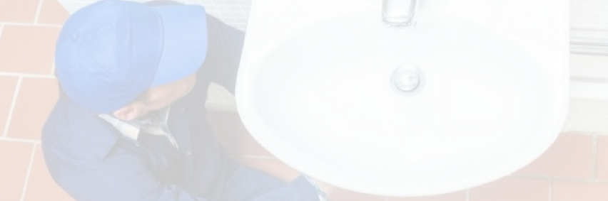 Person in blue cap leaning beside a large white hanging lamp overhead.
