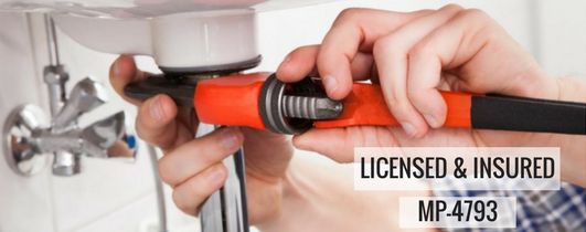 Hand gripping red plumbing tools under a sink beside a “Licensed & Insured” label