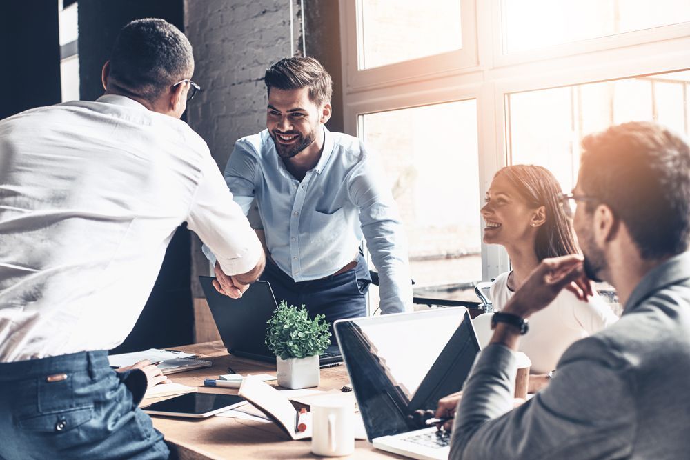 a man shakes hands with another man in an office