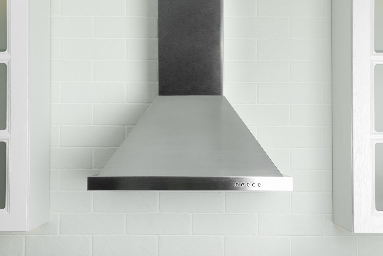 A kitchen under construction with a stainless steel hood and stove.