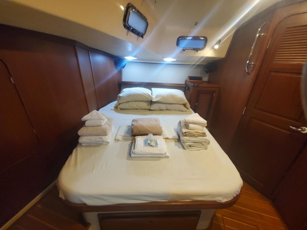 A bedroom on a boat with a bed and towels