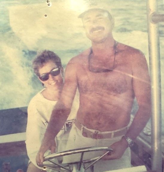 A man and a woman are posing for a picture on a boat.