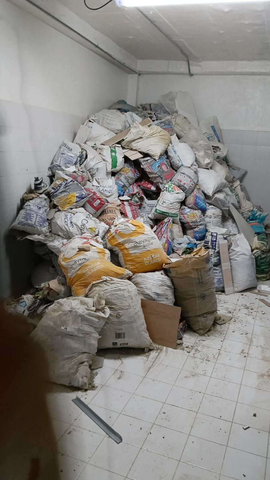Una habitación llena de bolsas de basura en el suelo.