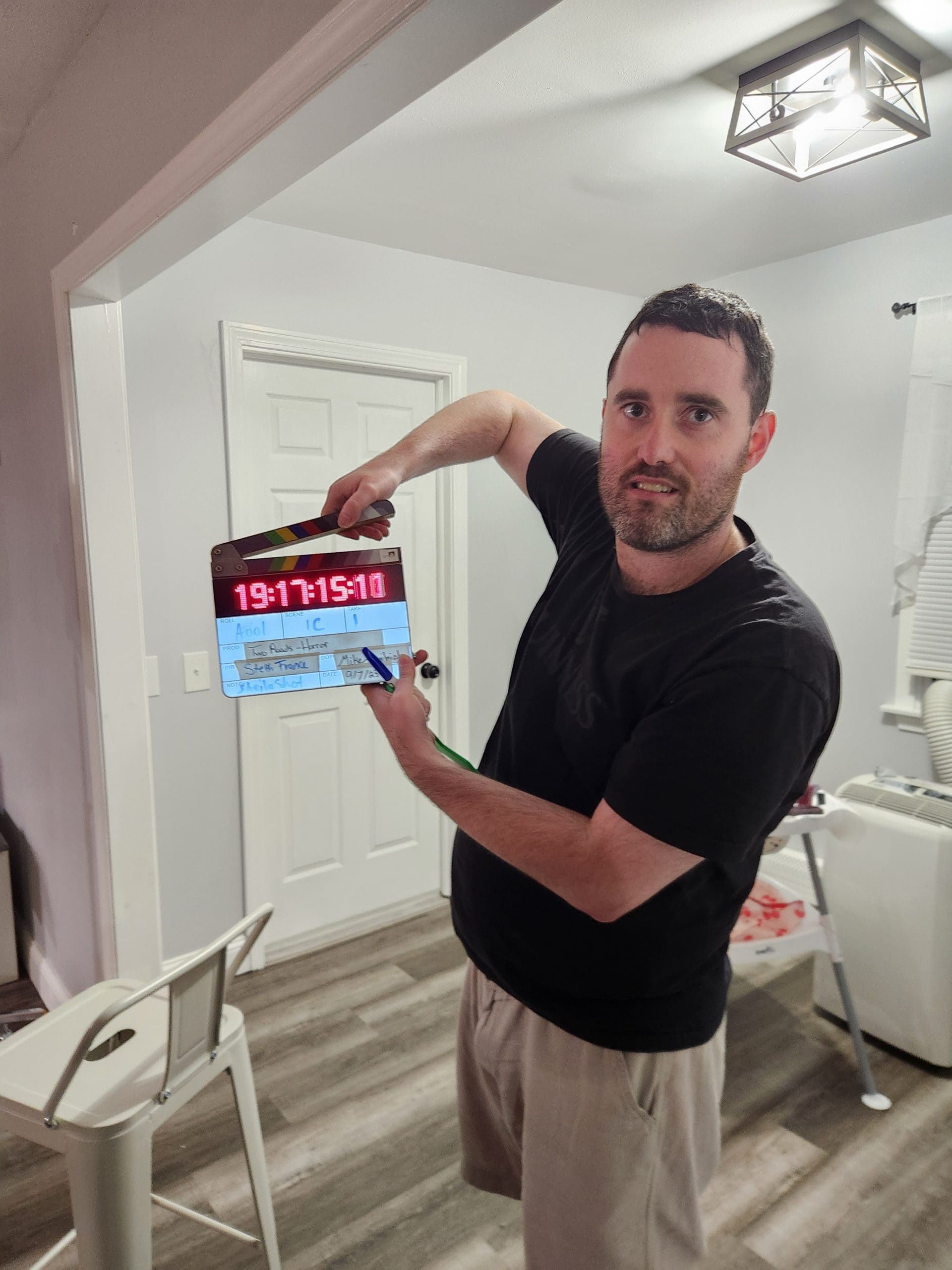Man holding a tablet with a red digital display in a bright home kitchen