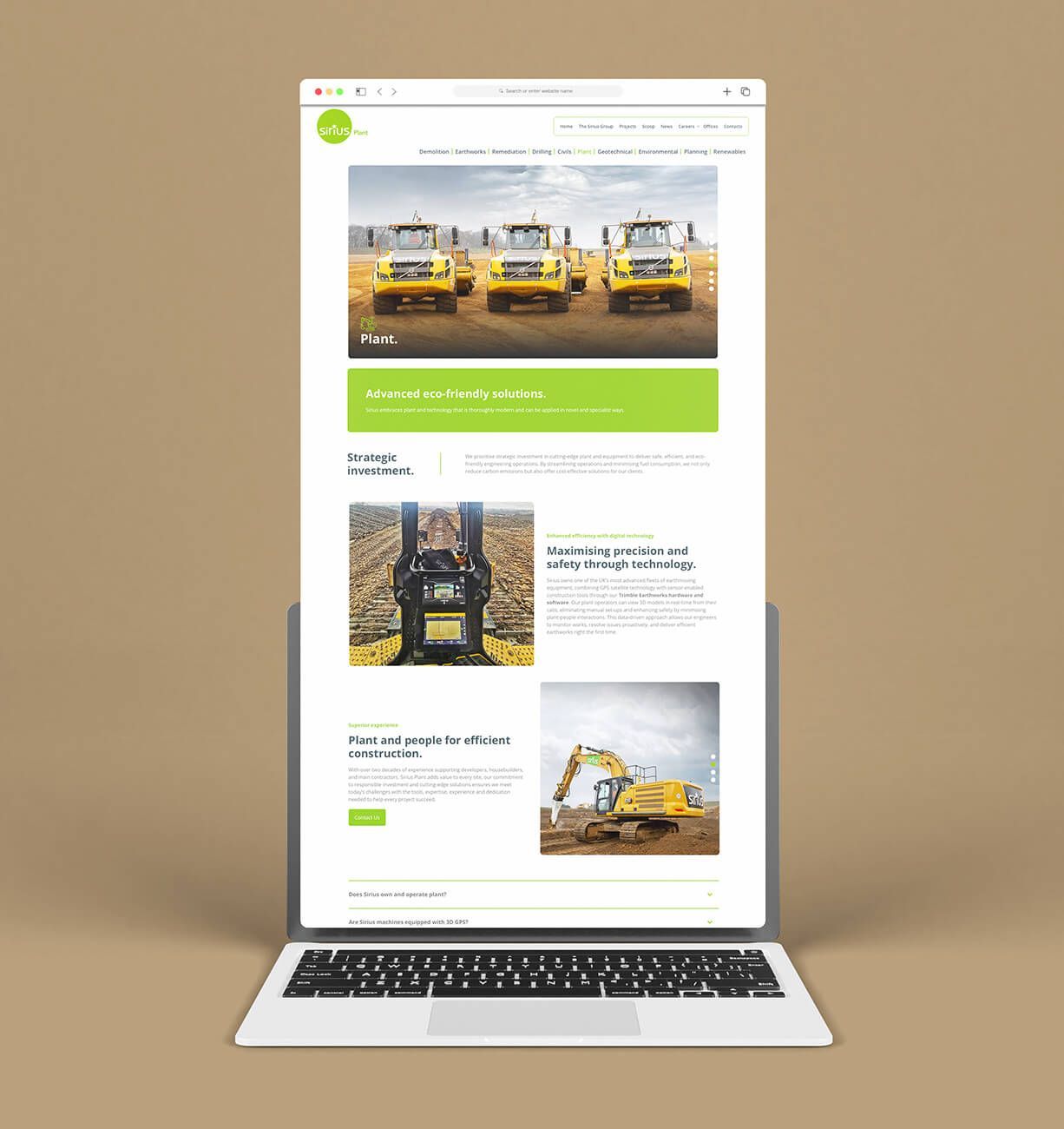 Laptop displaying a construction company website with yellow heavy machinery and project photos