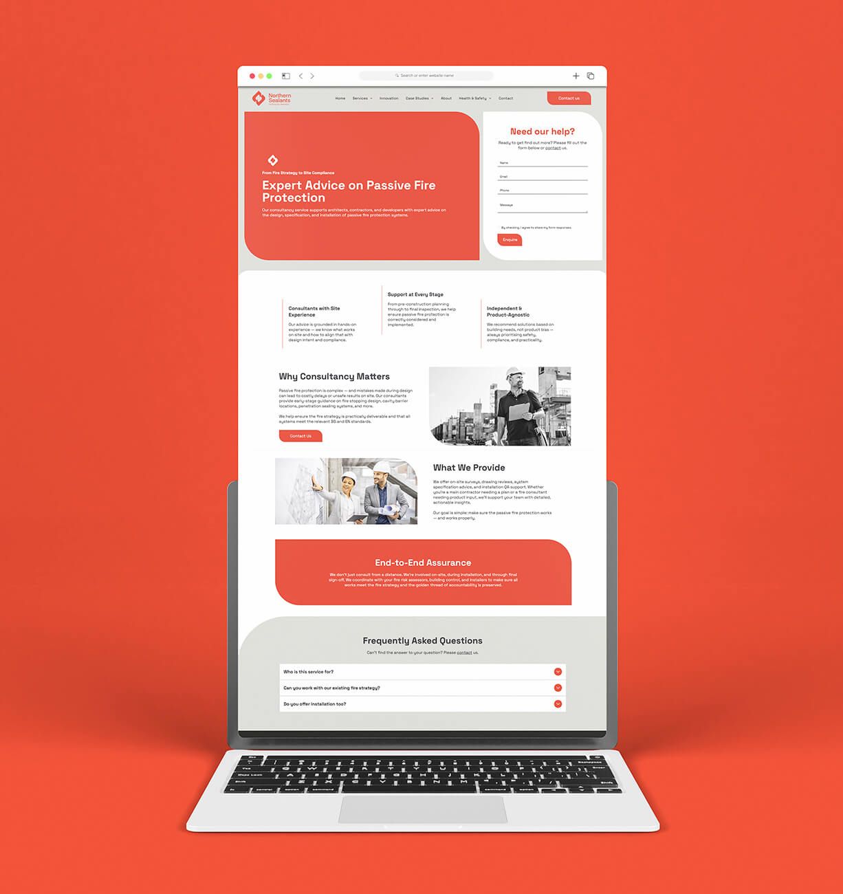 Laptop displaying a modern red-and-white website homepage on a red background