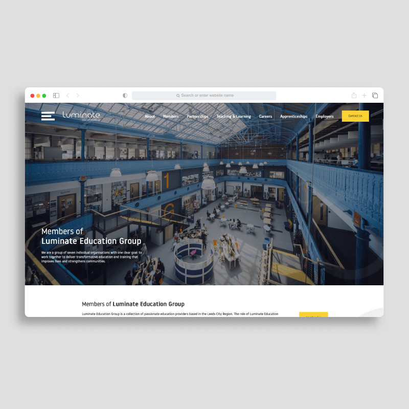 Website homepage showing a large industrial interior with blue steel beams and a yellow button in the top right