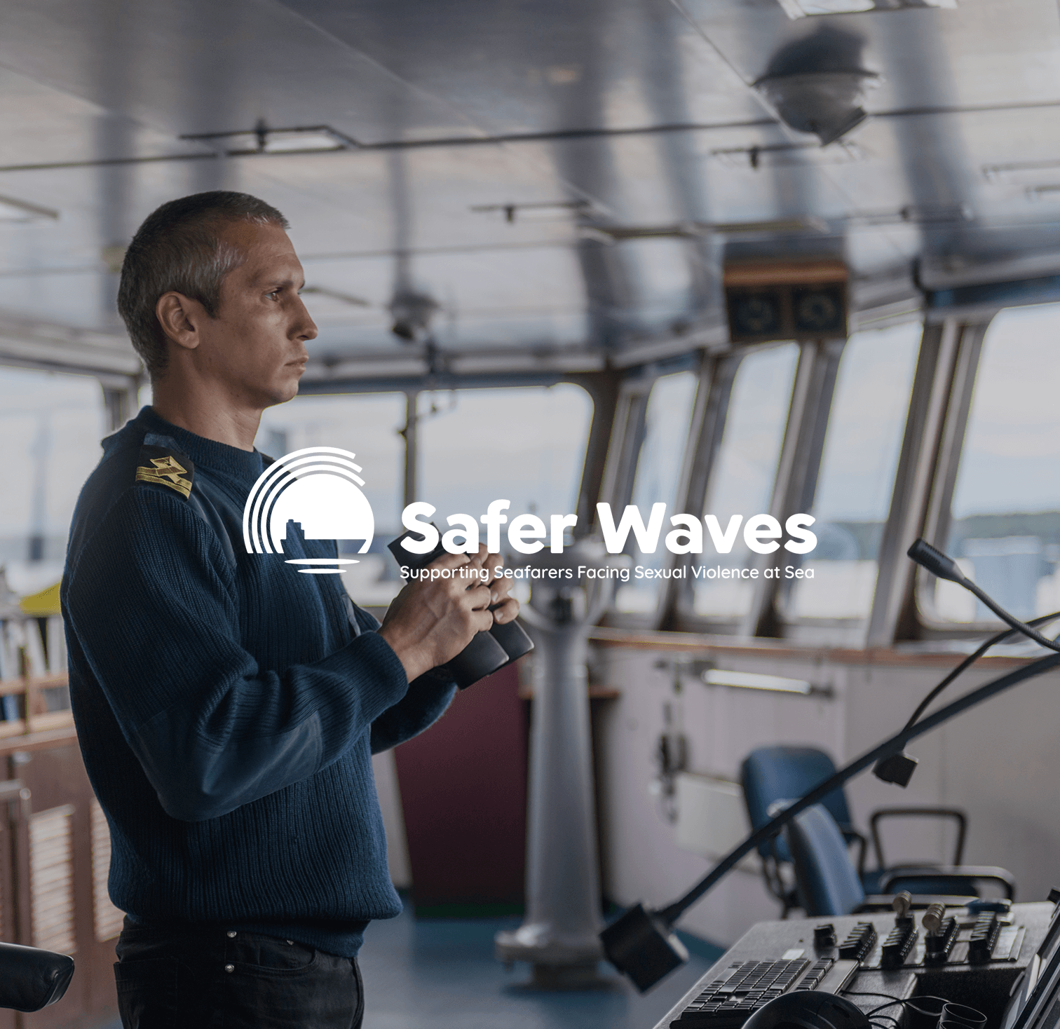 Man standing in a ship's bridge with navigation controls and a Safer Waves logo overlay