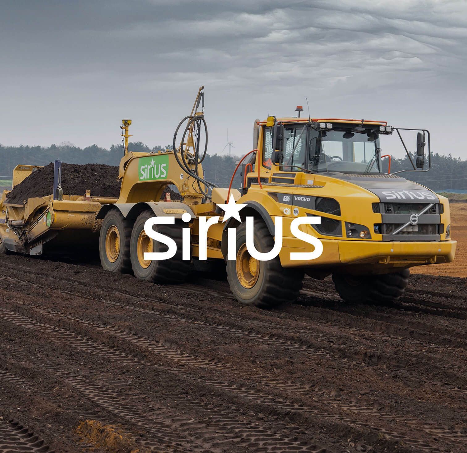Yellow construction truck with dirt-covered trailer on a muddy road under cloudy sky