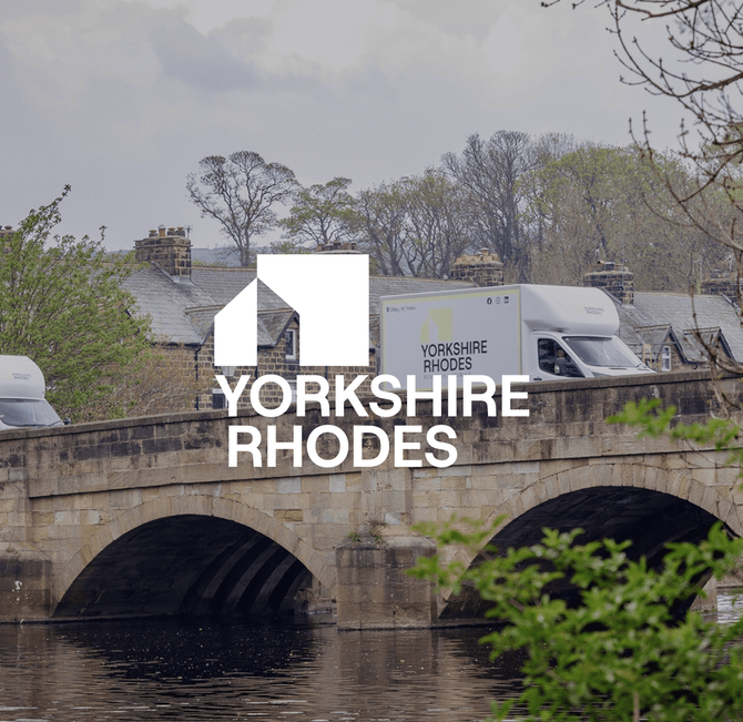 Stone bridge over a river with a Yorkshire Rhodes logo overlaid in the center