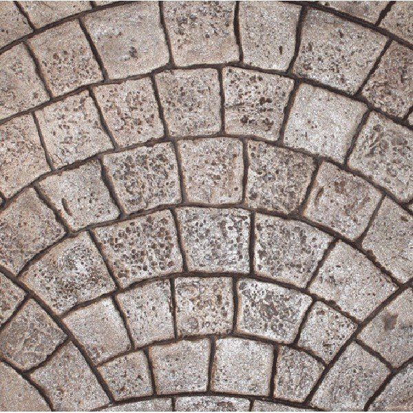 A pattern of weathered, light brown cobblestones arranged in concentric semi-circular arcs.