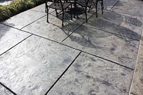 A gray stone-patterned concrete patio with square tiles, partially shaded by outdoor furniture.
