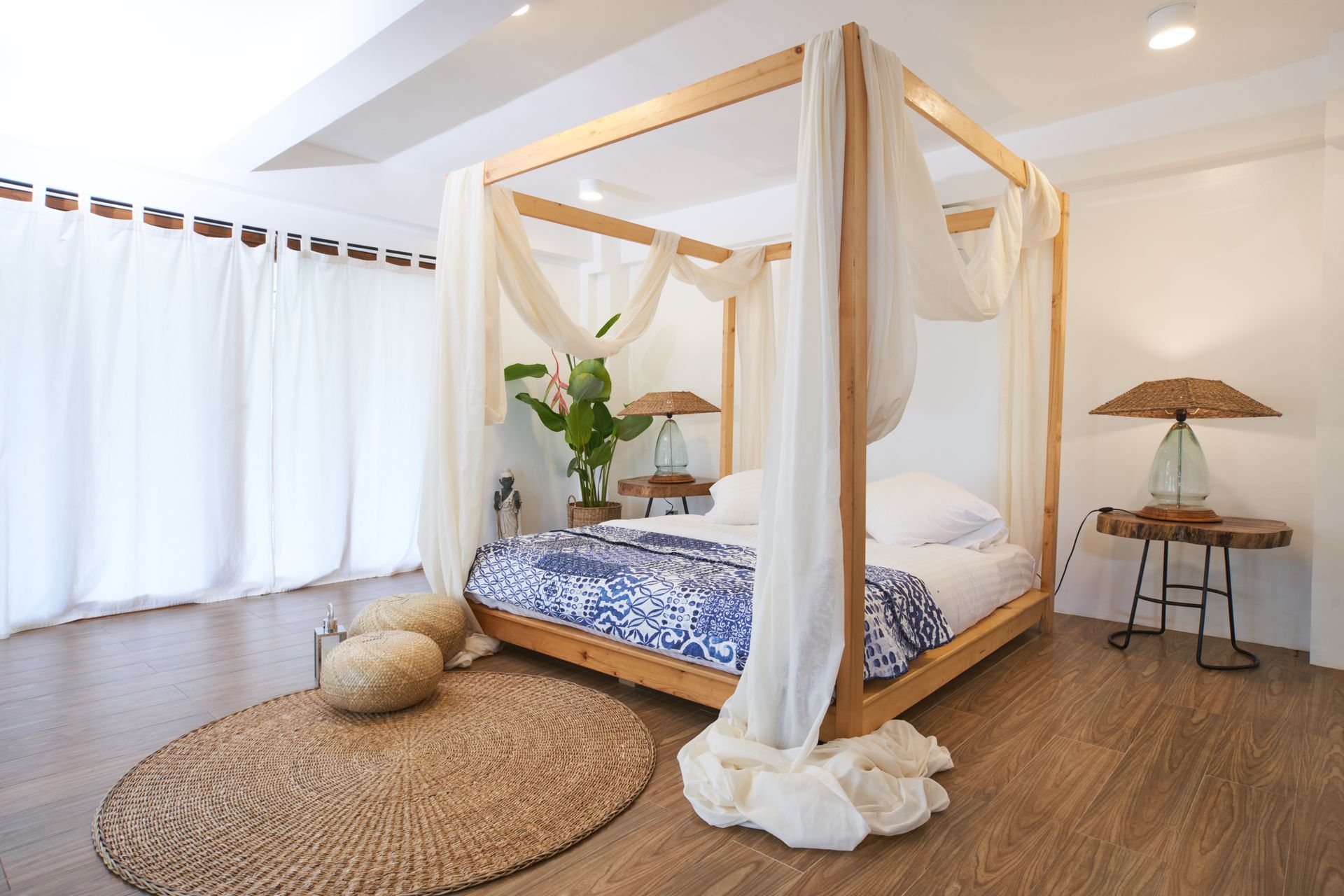 A bedroom with a canopy bed and white curtains