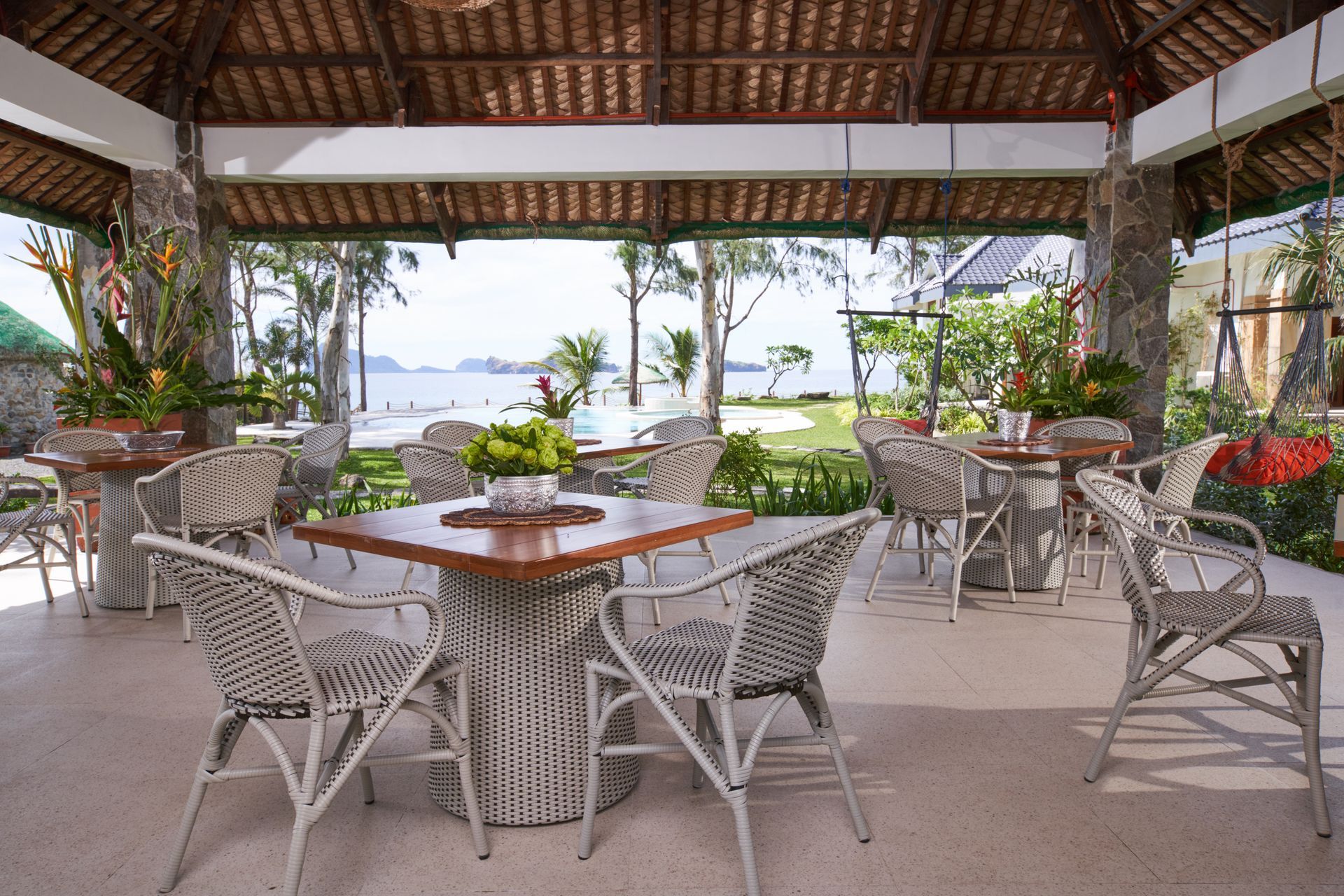A restaurant with tables and chairs with a view of the ocean