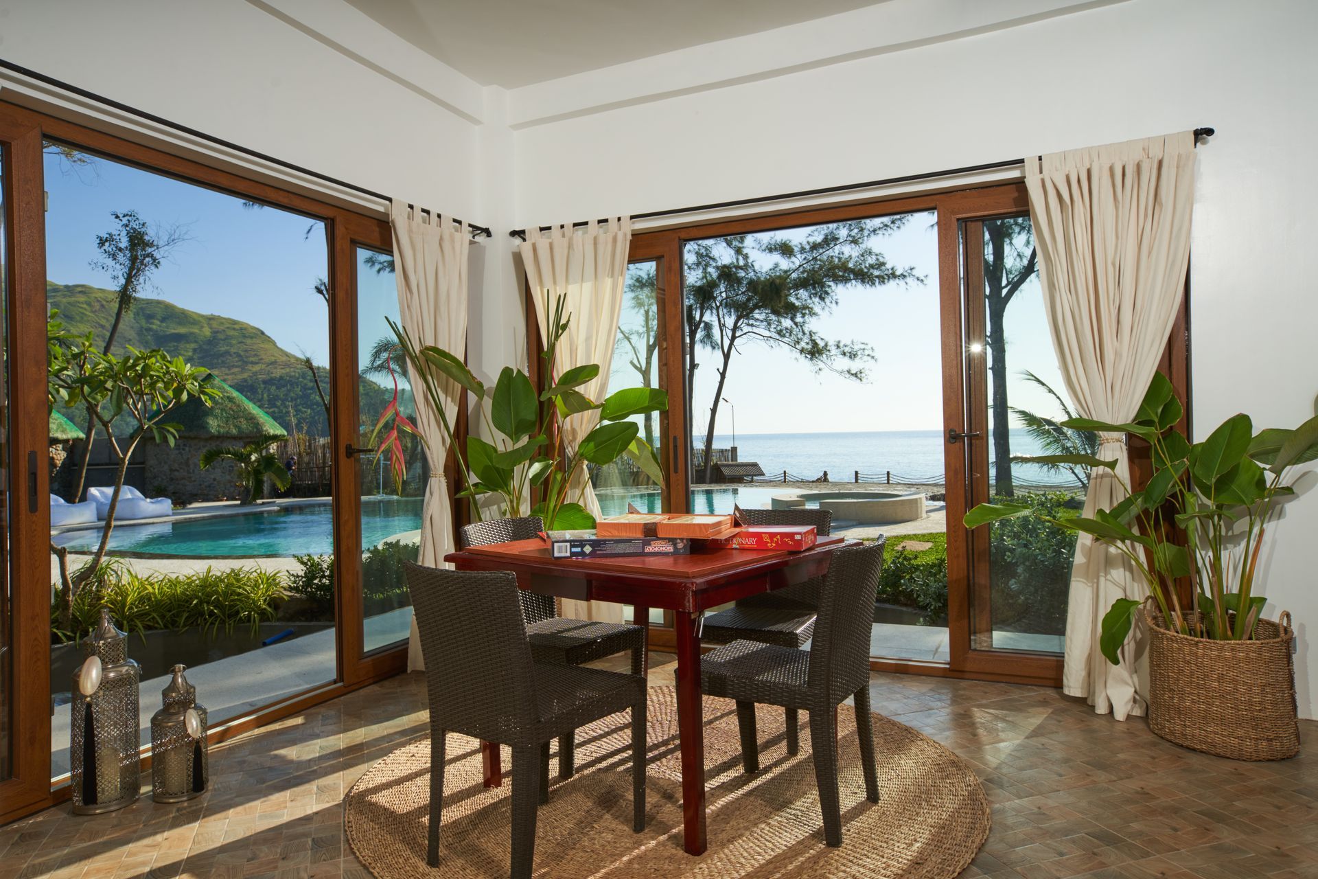 A dining room with a table and chairs and a view of the ocean.