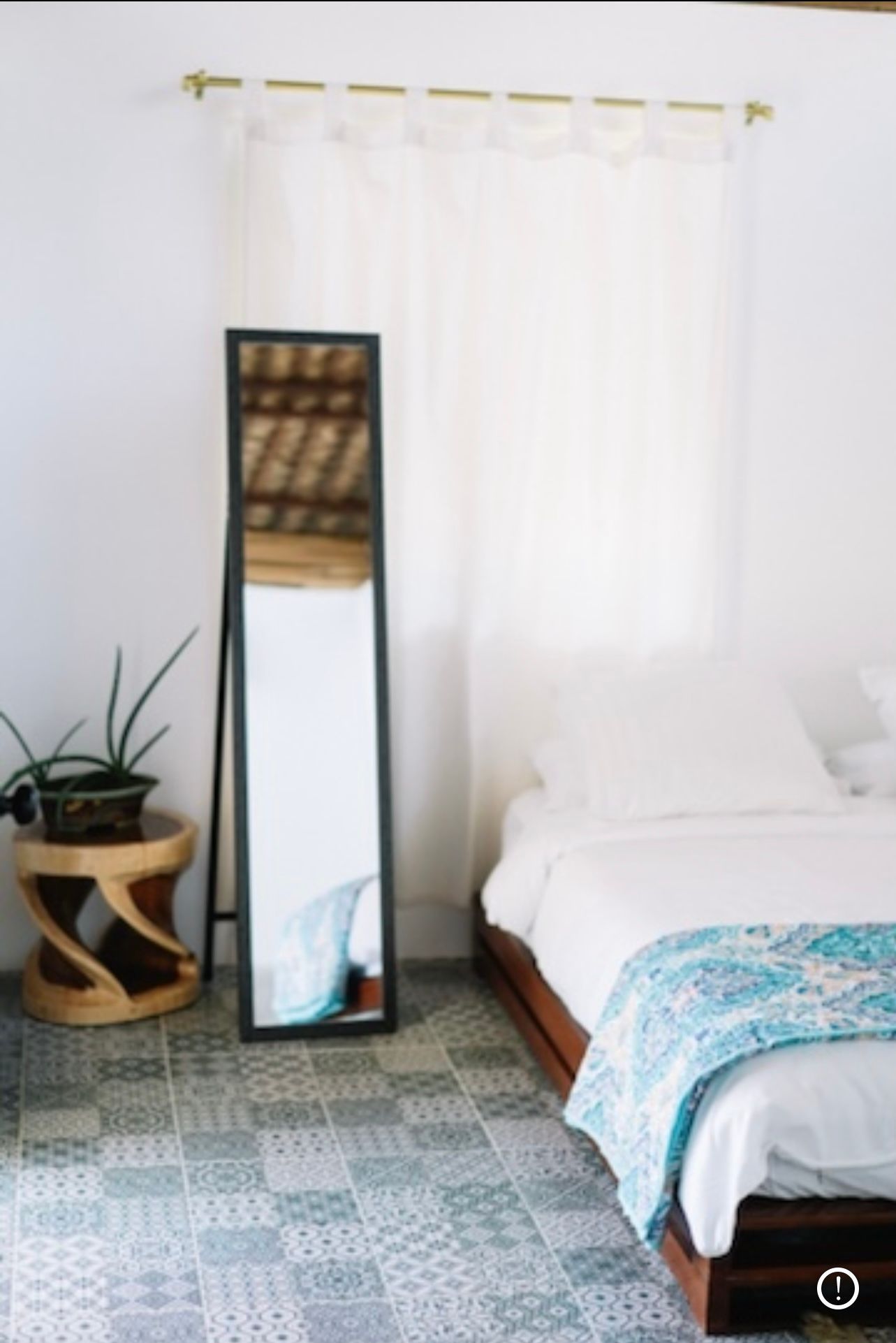 A bedroom with a bed and a full length mirror