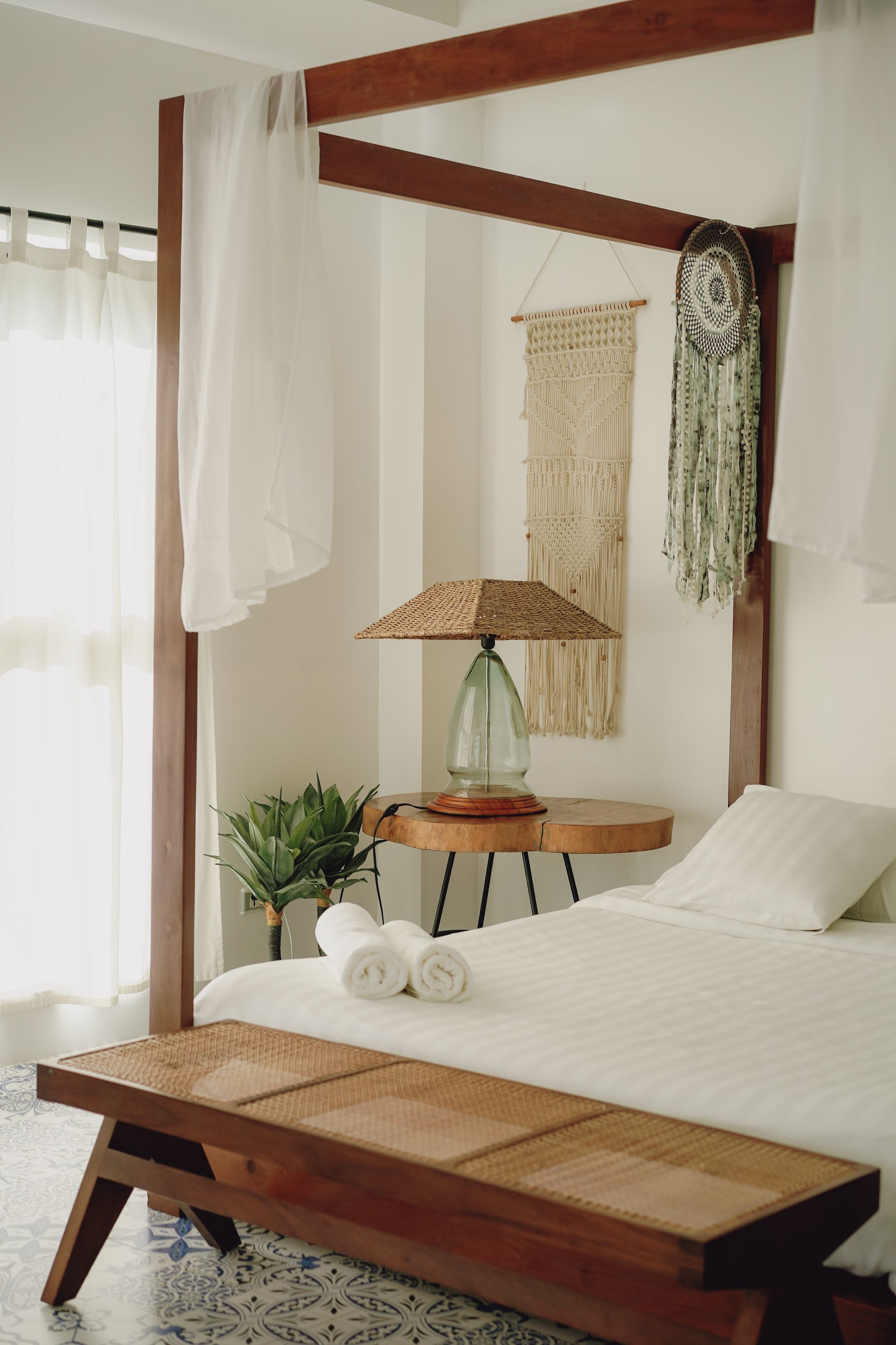 A bedroom with a canopy bed and a wooden bench