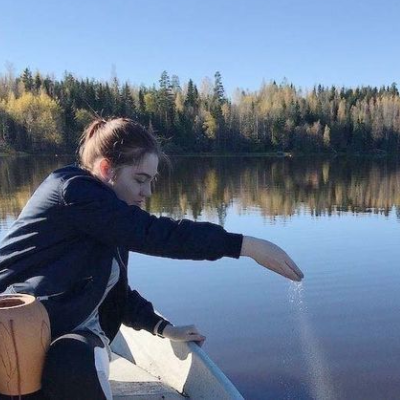 Woman scattering ashes into a body of water