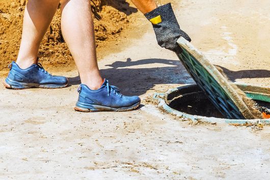 A man is inspecting a septic. A man is inspecting a septic.