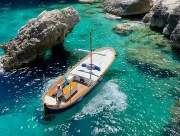 Barco privativo navegando próximo aos Faraglioni em Capri
