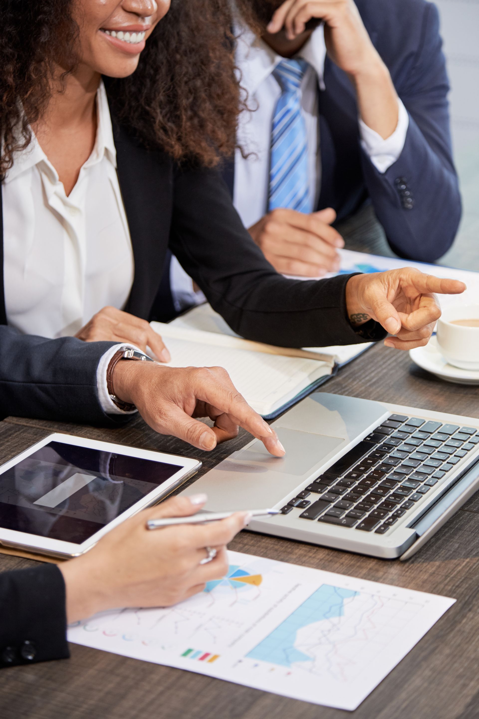A group of people are sitting at a table looking at a laptop.
