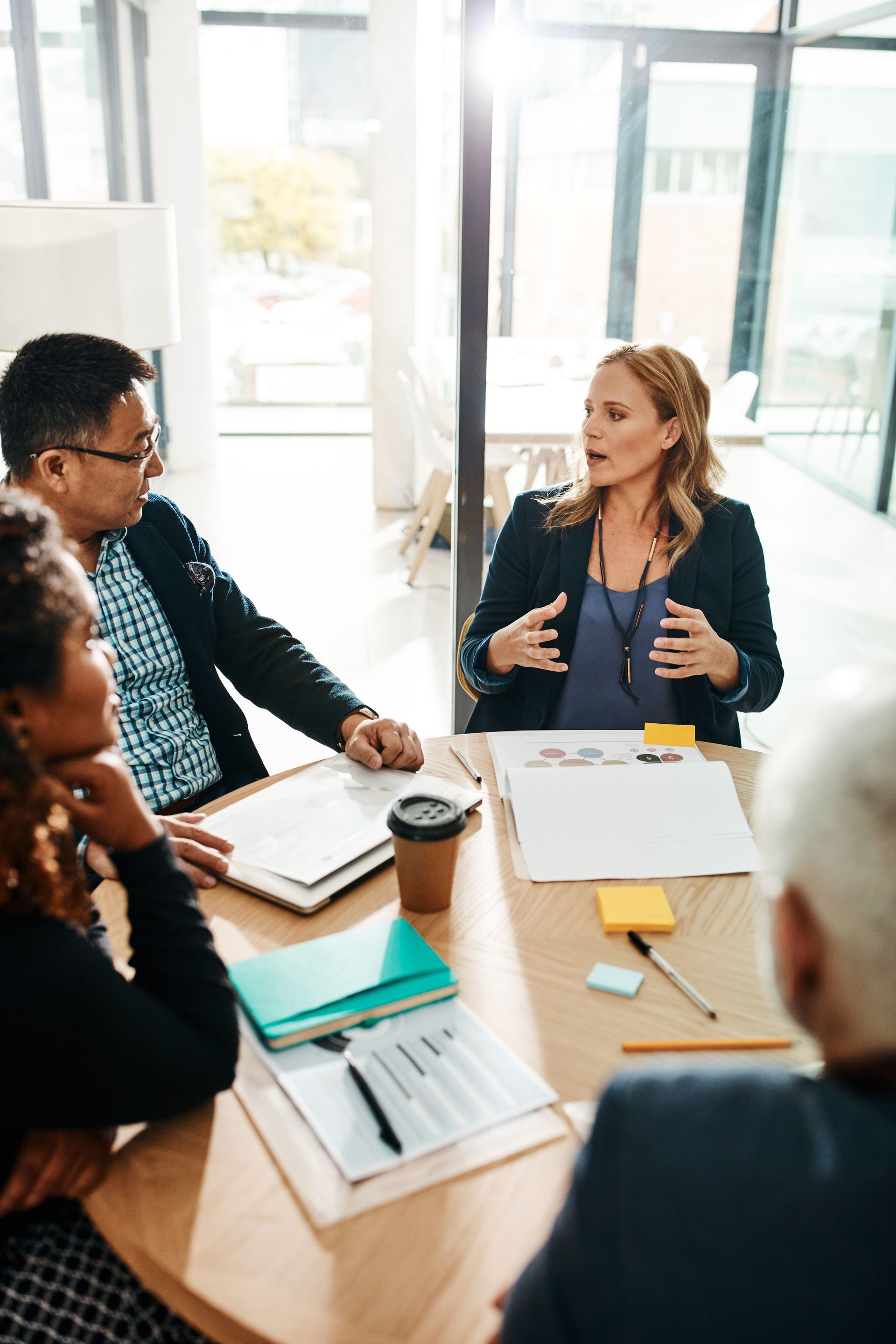 A group of people are sitting around a table having a meeting.