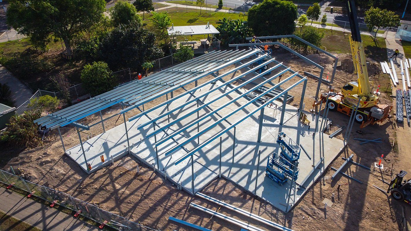 An aerial view of a building under construction with a crane in the background.