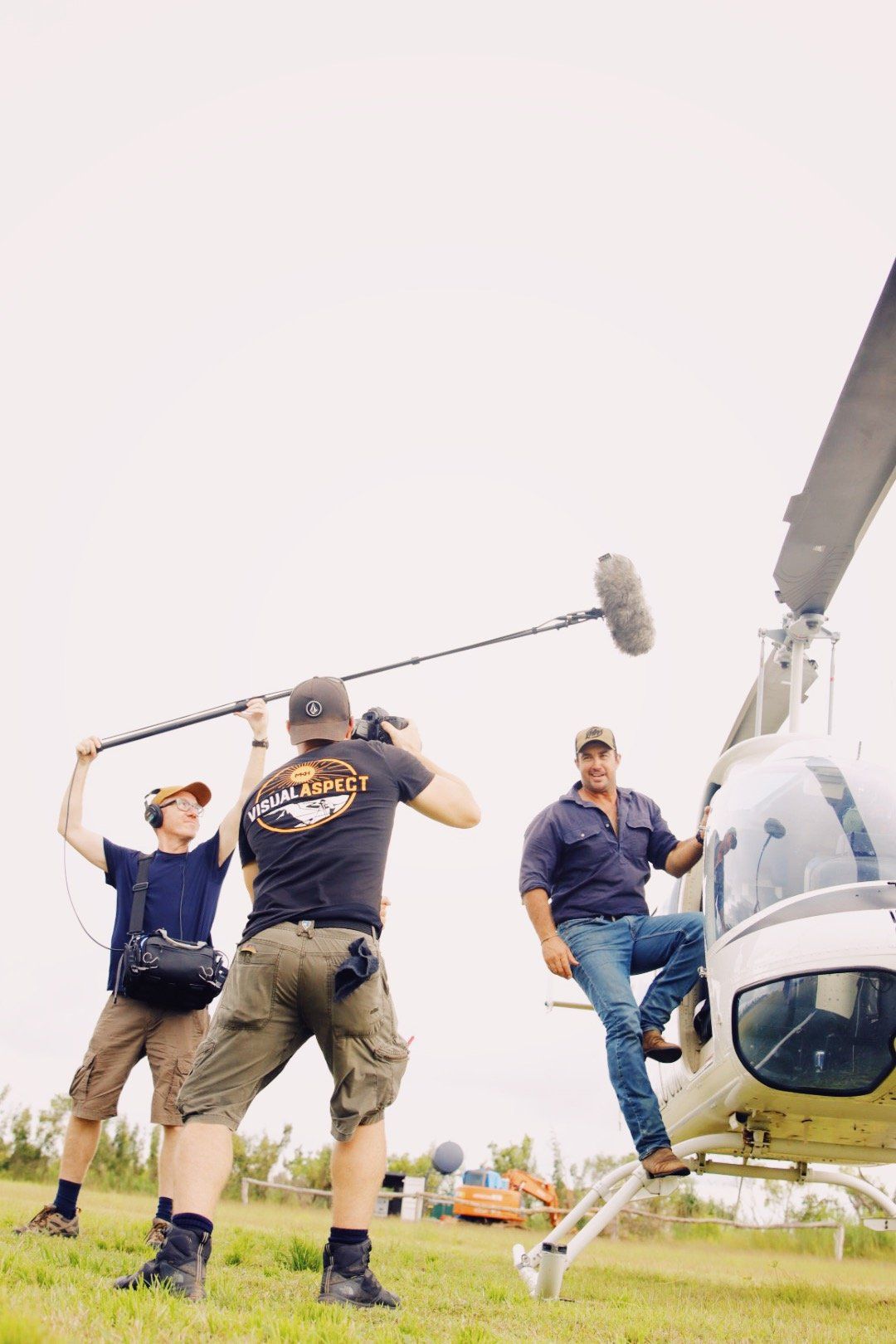 A group of men are standing in front of a helicopter.