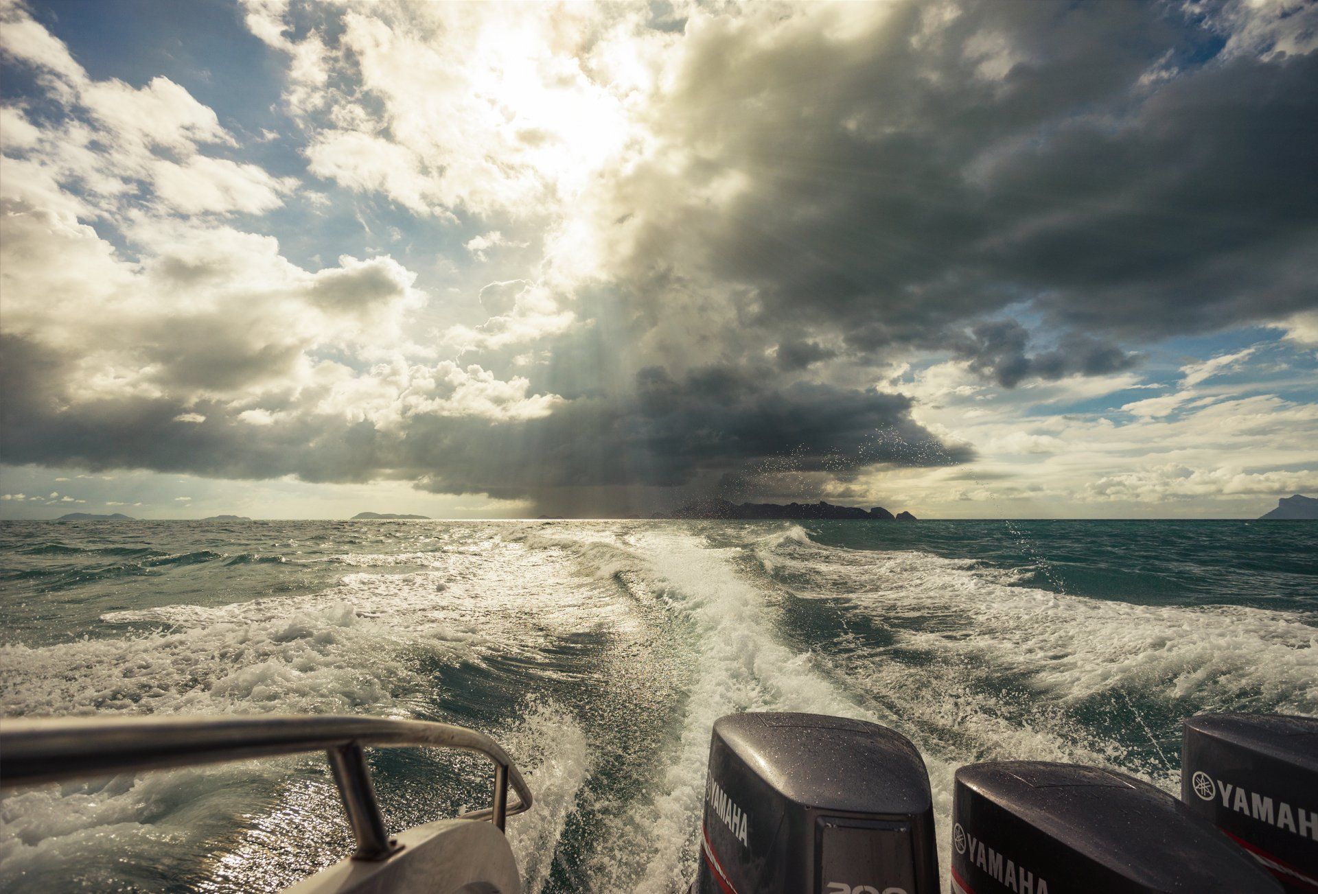 A boat is going through the ocean on a cloudy day.