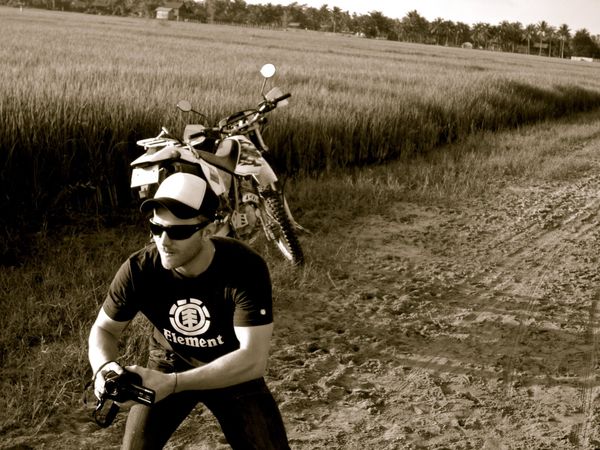 A man wearing a shirt that says element is standing in a field