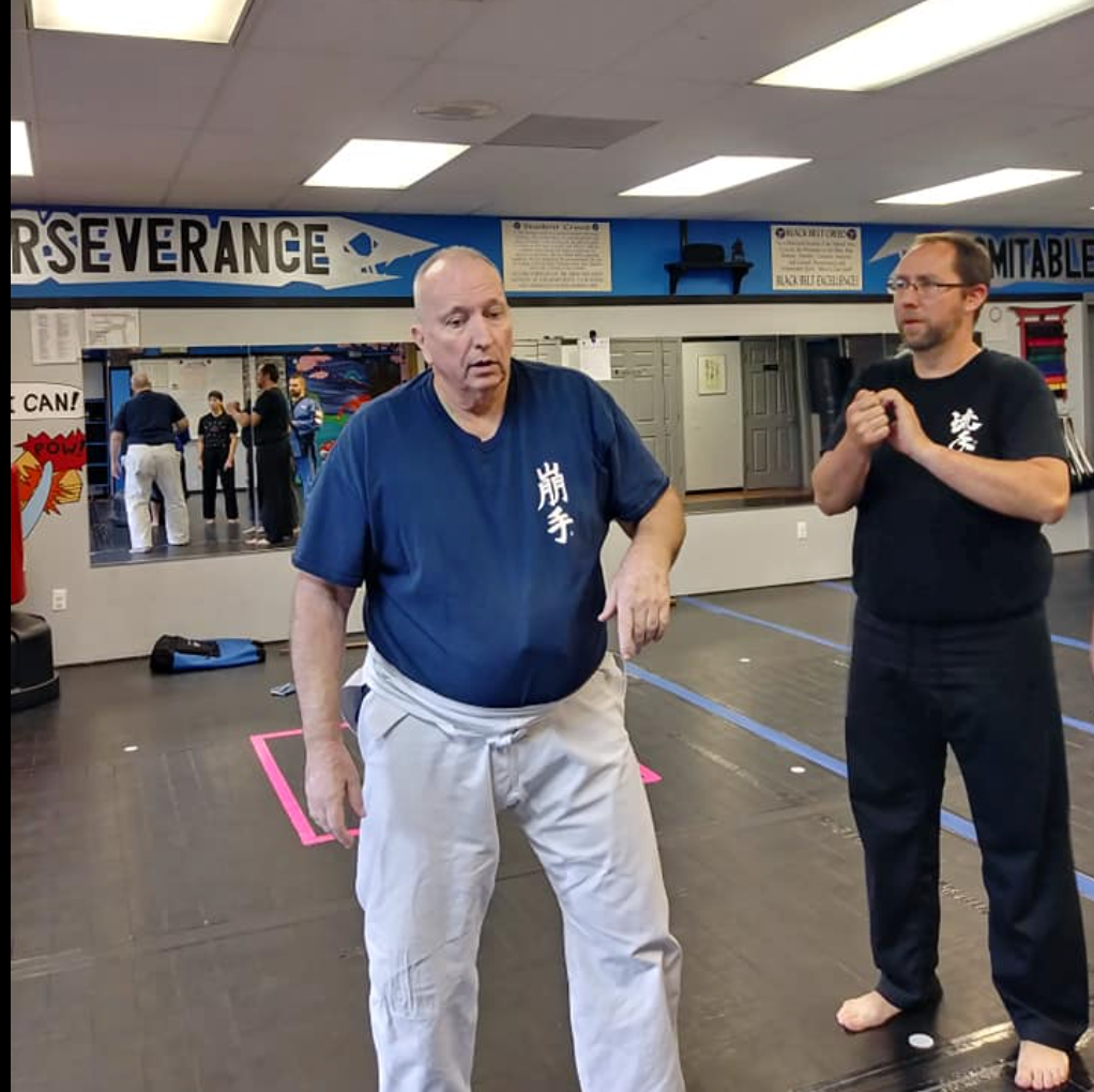 A man and a boy pose for a picture in a gym