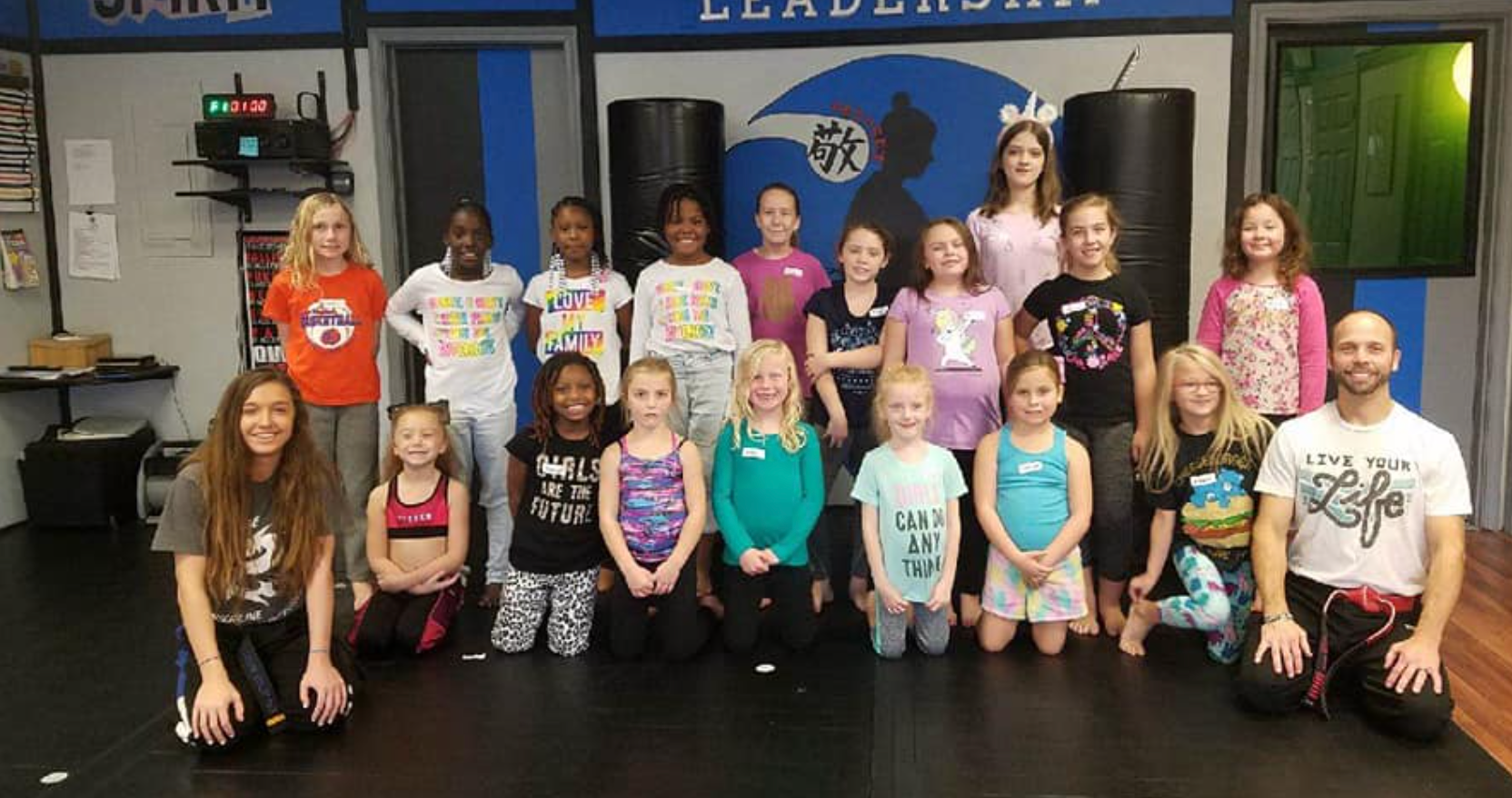 A group of children are posing for a picture in a gym.