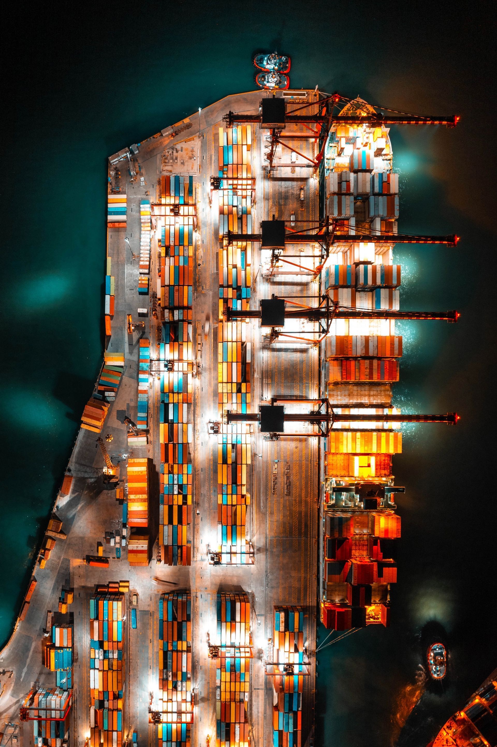 an aerial view of a large container ship docked in a harbor at night .