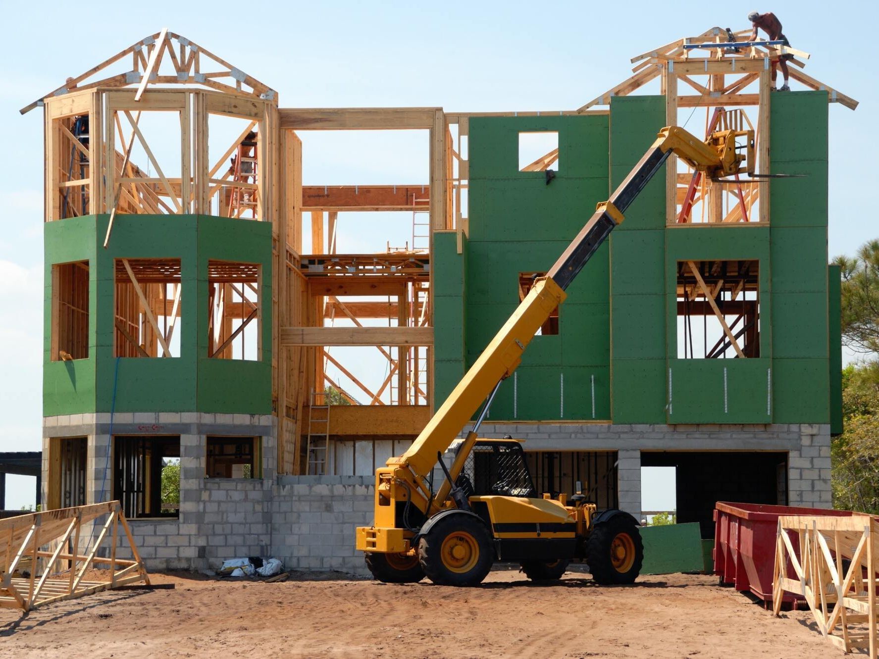 a yellow crane is being used to build a house