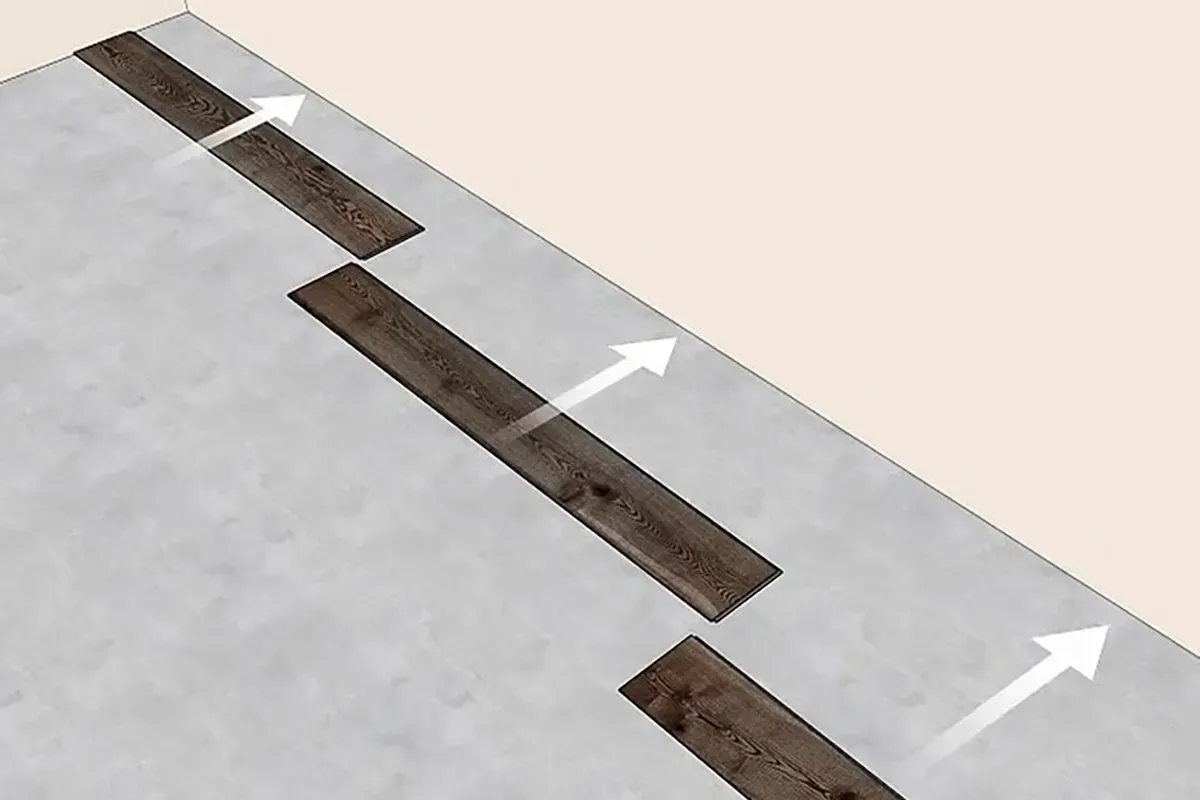 Installing the first row of vinyl plank flooring.